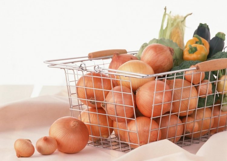 Руки считают деньги рядом с продуктовой корзиной